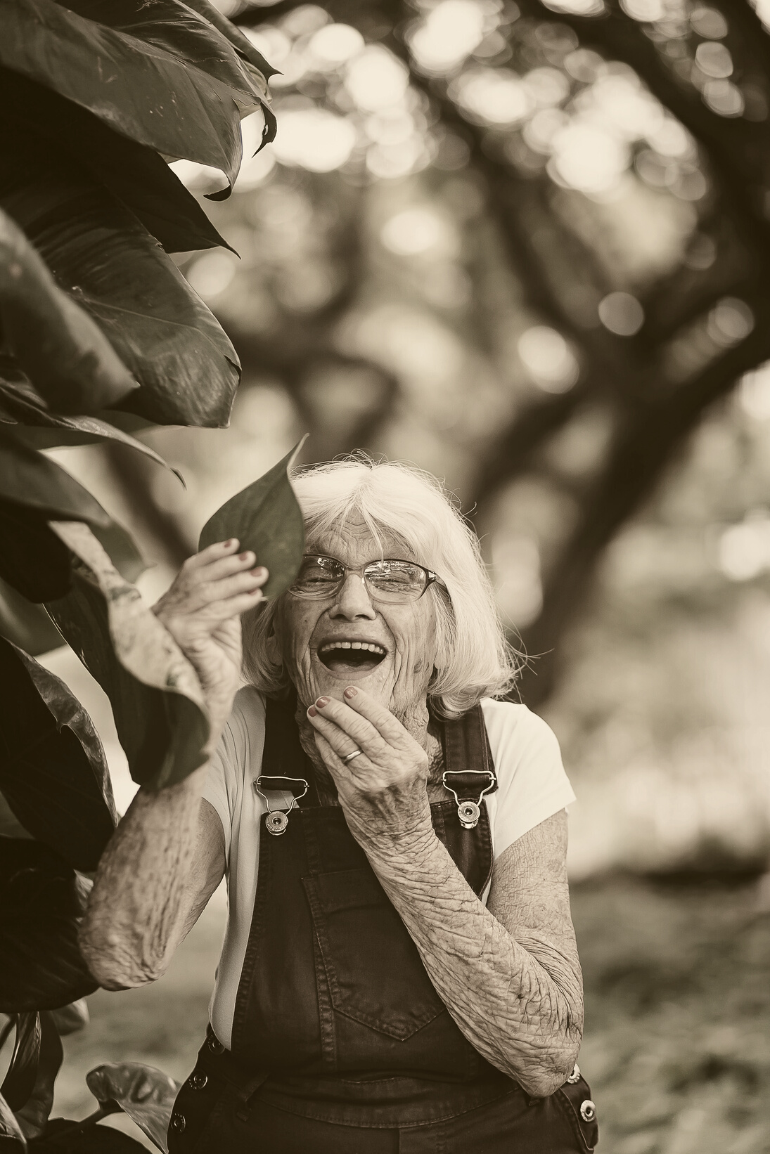 Selective Focus Photography of Woman Holding Green Leaf